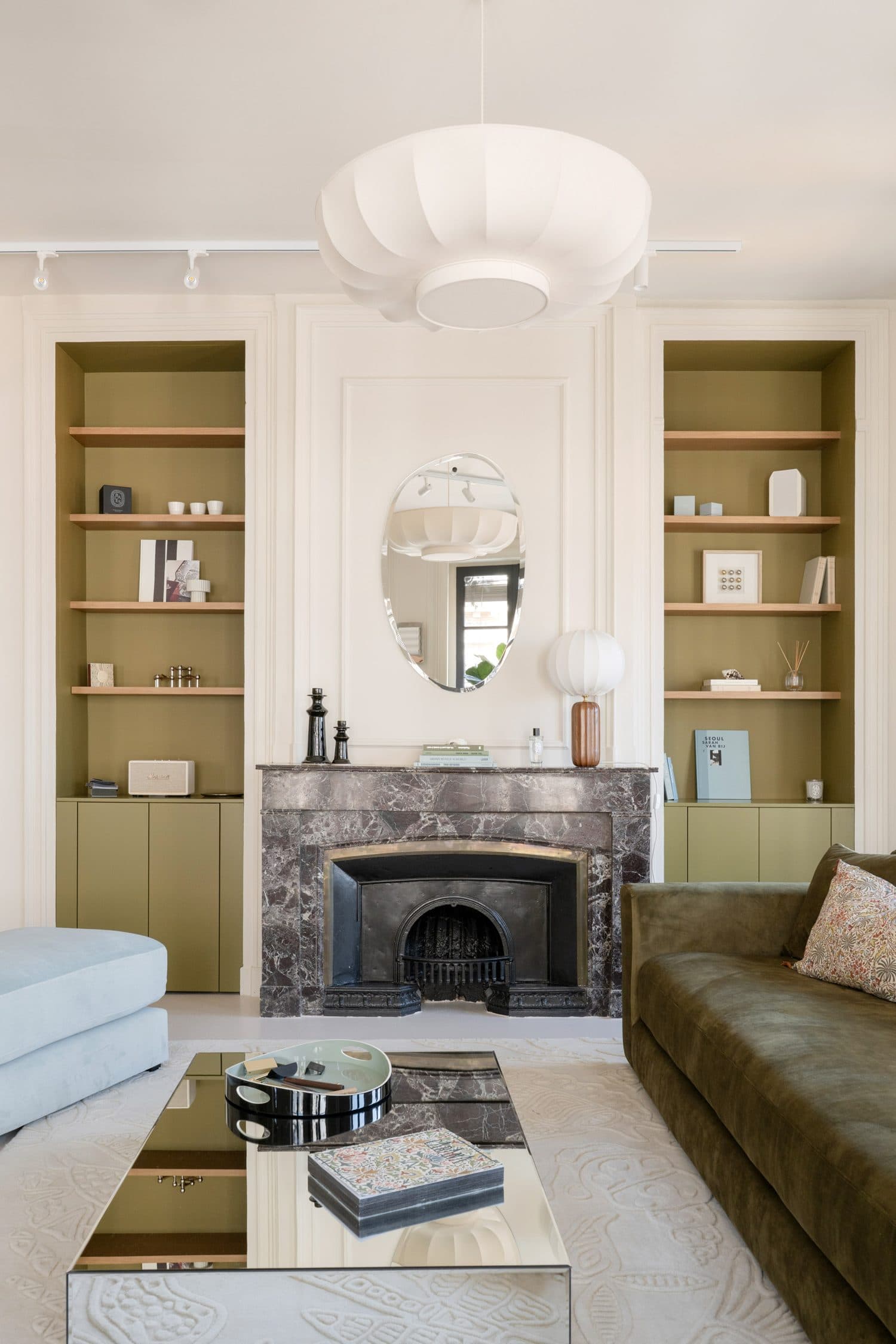 Séjour, niches vert olive, cheminée marbre et miroir ovale