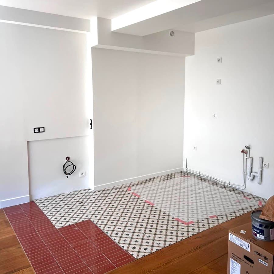 Espace cuisine vide avec carrelage et parquet, avant pose